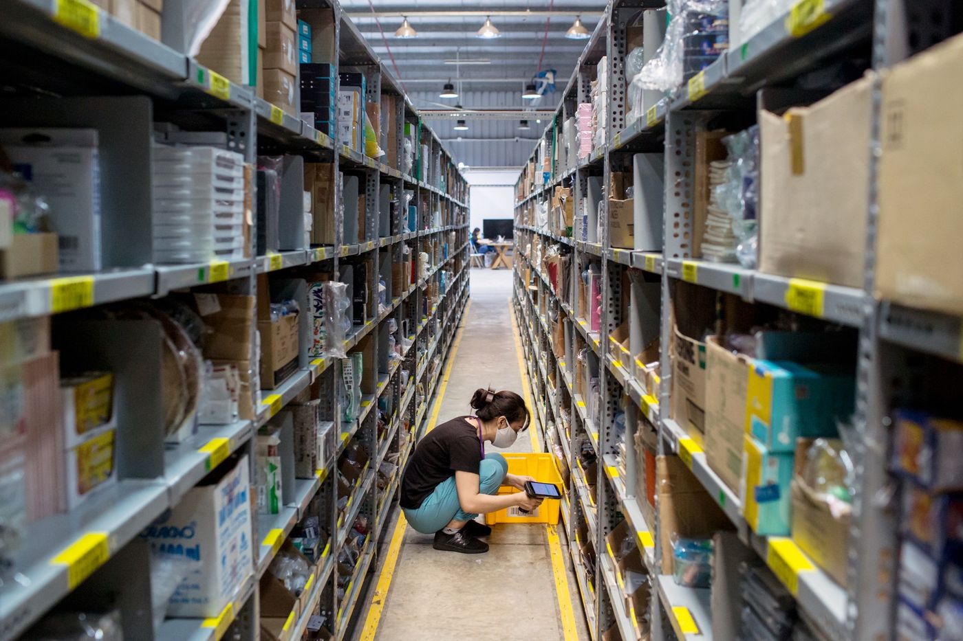 Nhân viên quét dọn và kiểm tra các mặt hàng trên kệ.